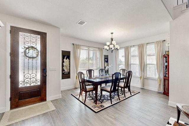 1979 Frediano Ln, Mclendon Chisholm, TX 75032 - dining room with baseboards, light wood-type flooring, a chandelier, and visible vents