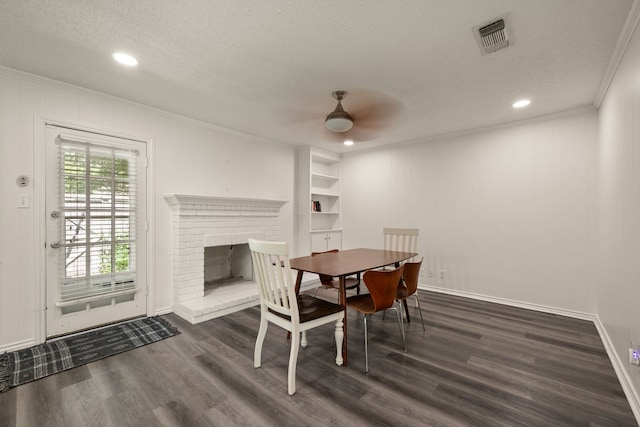 dining space featuring visible vents, dark wood-type flooring, crown molding, baseboards, and a textured ceiling