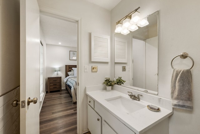 bathroom featuring connected bathroom, vanity, and wood finished floors
