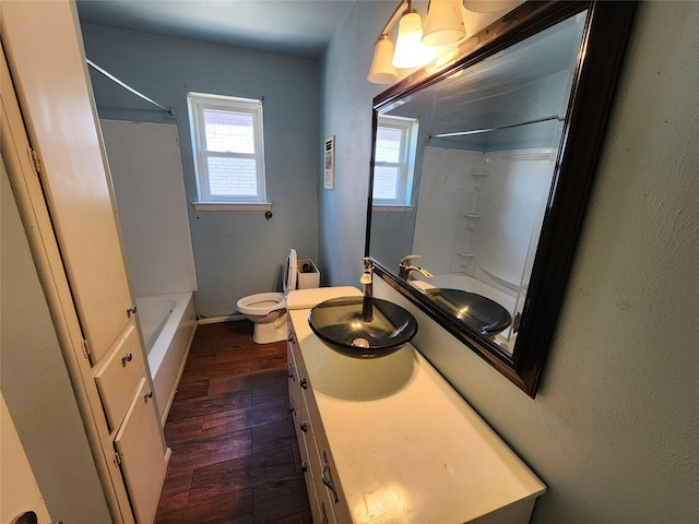 full bathroom featuring toilet, a healthy amount of sunlight, vanity, and wood-type flooring