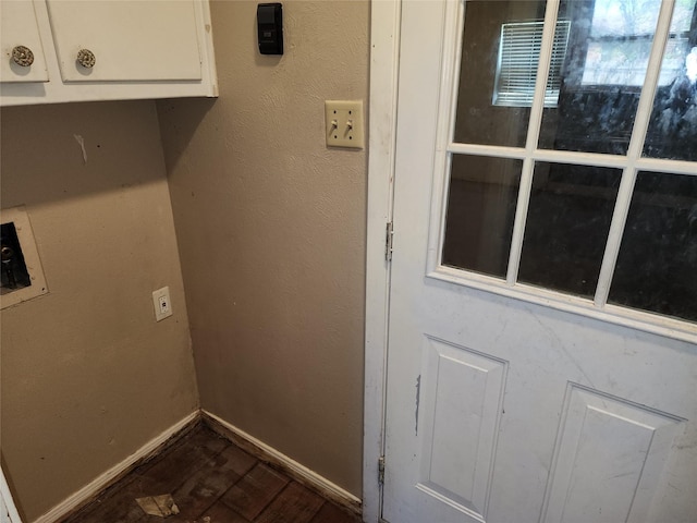 laundry room with baseboards, a textured wall, dark wood-type flooring, hookup for a washing machine, and cabinet space
