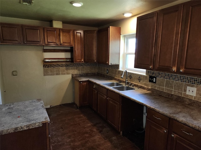kitchen featuring a sink, visible vents, decorative backsplash, and dark wood-style floors