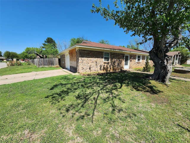 ranch-style house featuring driveway, a front lawn, brick siding, a garage, and fence