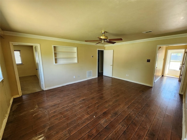 empty room with ornamental molding, dark wood finished floors, and visible vents