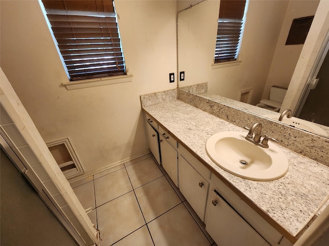 bathroom featuring tile patterned floors, toilet, vanity, and baseboards