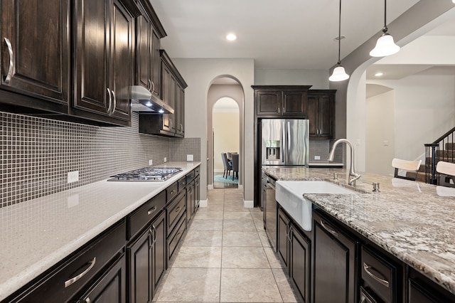 3 Asheville Ln, Trophy Club, TX 76262 - kitchen with arched walkways, a sink, under cabinet range hood, stainless steel appliances, and recessed lighting