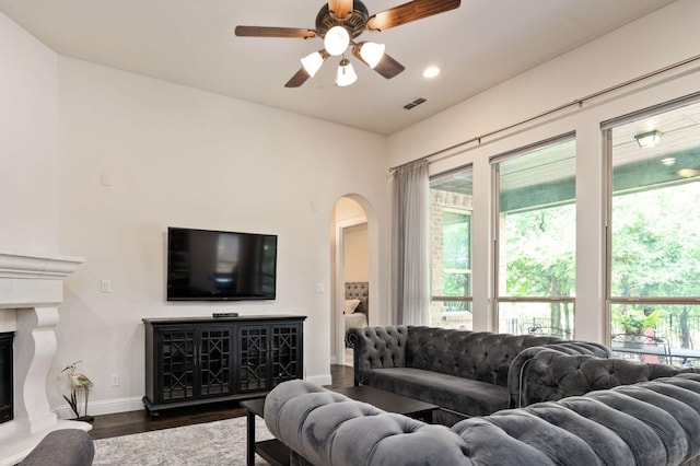 3 Asheville Ln, Trophy Club, TX 76262 - living room with arched walkways, dark wood-style floors, a ceiling fan, baseboards, and a fireplace