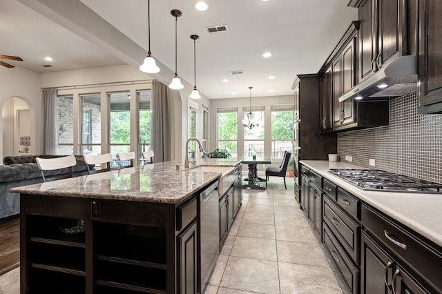 3 Asheville Ln, Trophy Club, TX 76262 - kitchen with stainless steel appliances, under cabinet range hood, a sink, tasteful backsplash, and a center island with sink