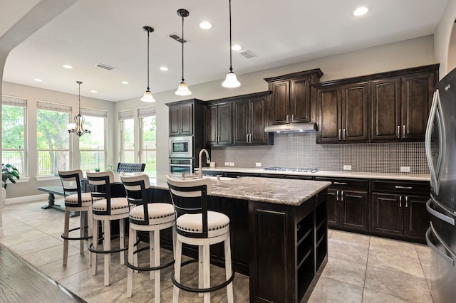 3 Asheville Ln, Trophy Club, TX 76262 - kitchen with stainless steel appliances, tasteful backsplash, a sink, a center island with sink, and a breakfast bar area