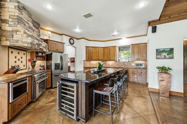 kitchen with stainless steel appliances, beverage cooler, tasteful backsplash, and a kitchen island
