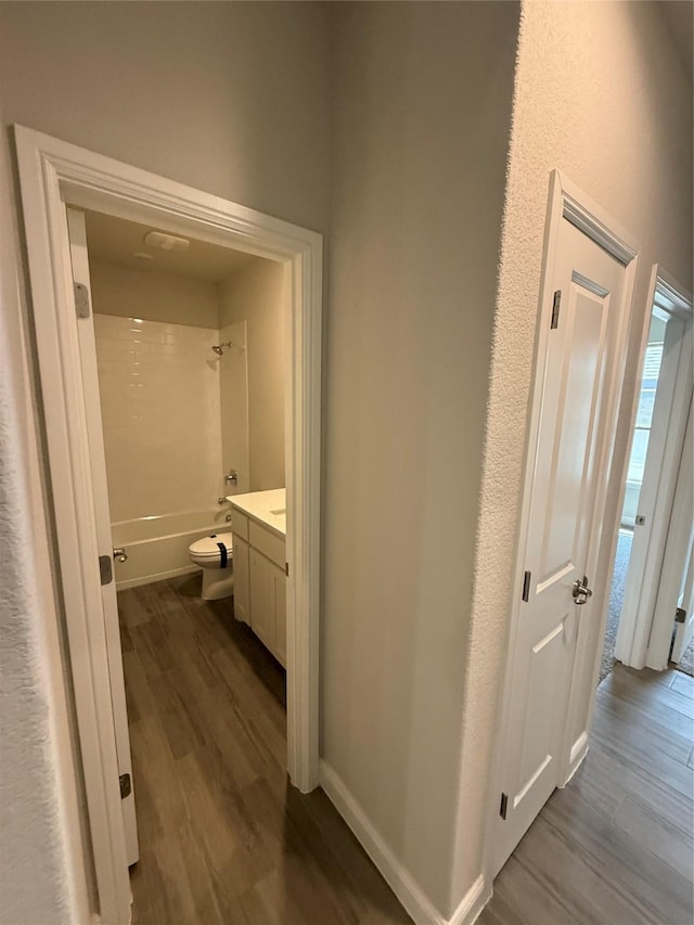 hall featuring dark wood-style floors and baseboards