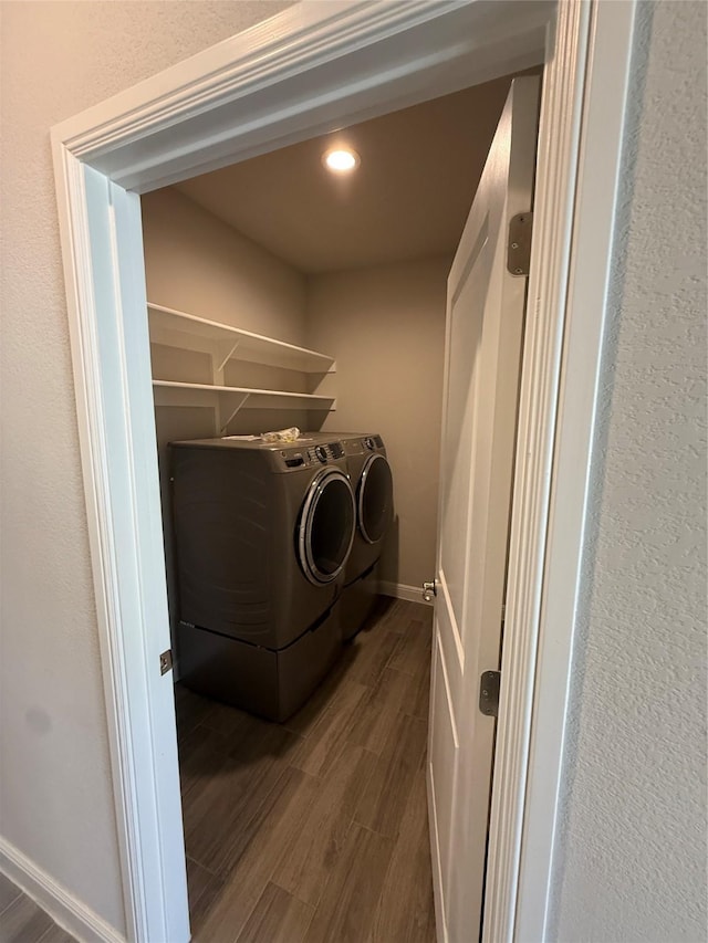 clothes washing area with recessed lighting, washer and dryer, laundry area, and dark wood finished floors