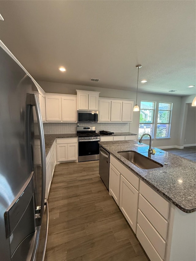 kitchen with recessed lighting, white cabinets, visible vents, stainless steel appliances, and a sink