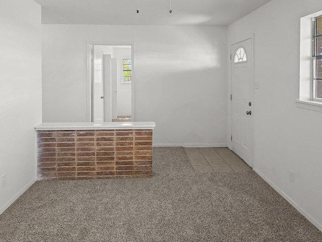 3103 Coggin Ave, Brownwood, TX 76801 - carpeted foyer entrance with tile patterned floors, baseboards, and a healthy amount of sunlight