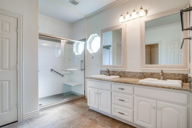 bathroom featuring visible vents, ornamental molding, a stall shower, and a sink