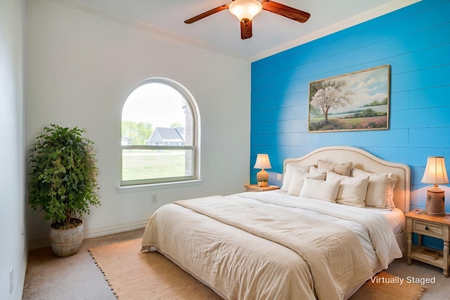 bedroom featuring carpet, wood walls, ceiling fan, baseboards, and crown molding