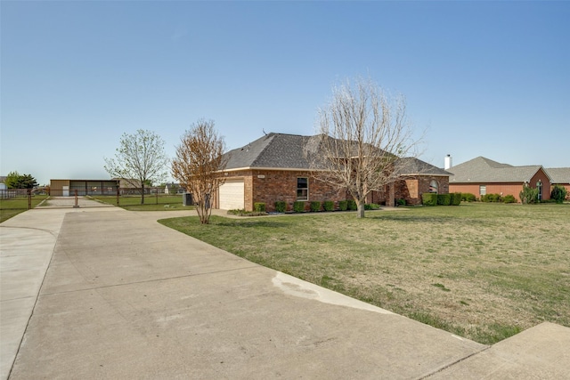 view of side of home with a lawn, driveway, brick siding, an attached garage, and fence