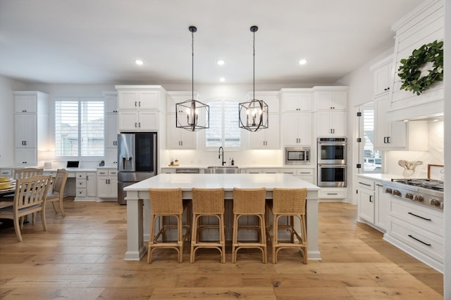 2720 Whirlaway Ct, Celina, TX 75009 - kitchen featuring appliances with stainless steel finishes, light countertops, a kitchen island, a sink, and white cabinets
