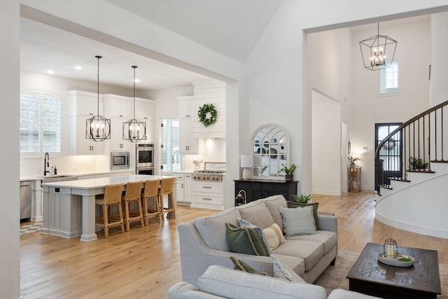 2720 Whirlaway Ct, Celina, TX 75009 - living room with a chandelier, light wood-style floors, stairway, a towering ceiling, and recessed lighting