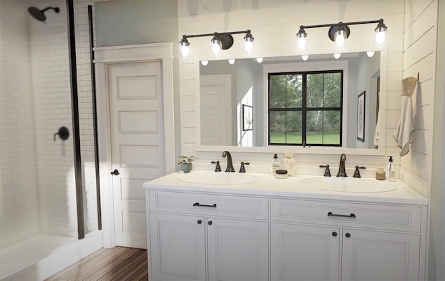 bathroom with wood finished floors, a sink, and double vanity