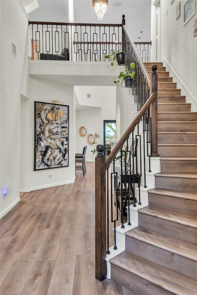 2325 Heather Ridge Dr, Flower Mound, TX 75028 - staircase with visible vents, baseboards, a chandelier, wood finished floors, and a towering ceiling