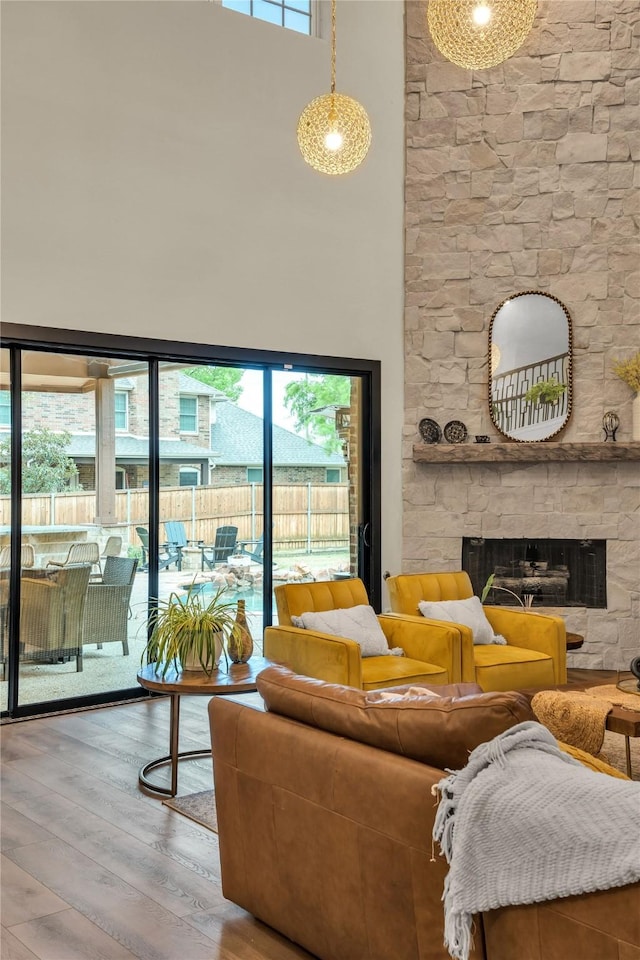 2325 Heather Ridge Dr, Flower Mound, TX 75028 - living area featuring a towering ceiling, a stone fireplace, wood finished floors, and a healthy amount of sunlight