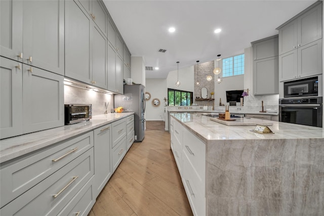 2325 Heather Ridge Dr, Flower Mound, TX 75028 - kitchen featuring freestanding refrigerator, black microwave, oven, decorative backsplash, and gray cabinetry