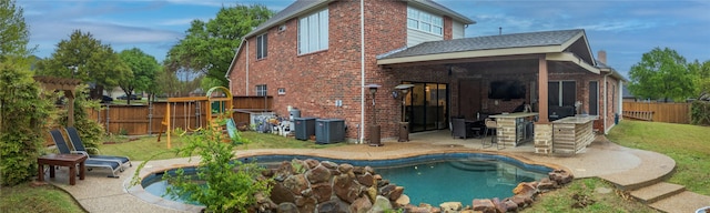 2325 Heather Ridge Dr, Flower Mound, TX 75028 - rear view of property with brick siding, fence, a patio, and a lawn