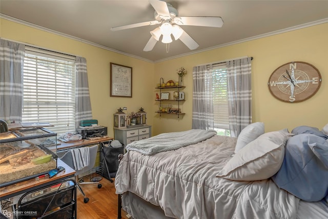 bedroom featuring ornamental molding, a ceiling fan, and wood finished floors