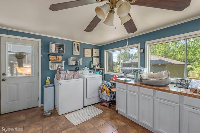 laundry area with crown molding, ceiling fan, independent washer and dryer, cabinet space, and dark tile patterned flooring