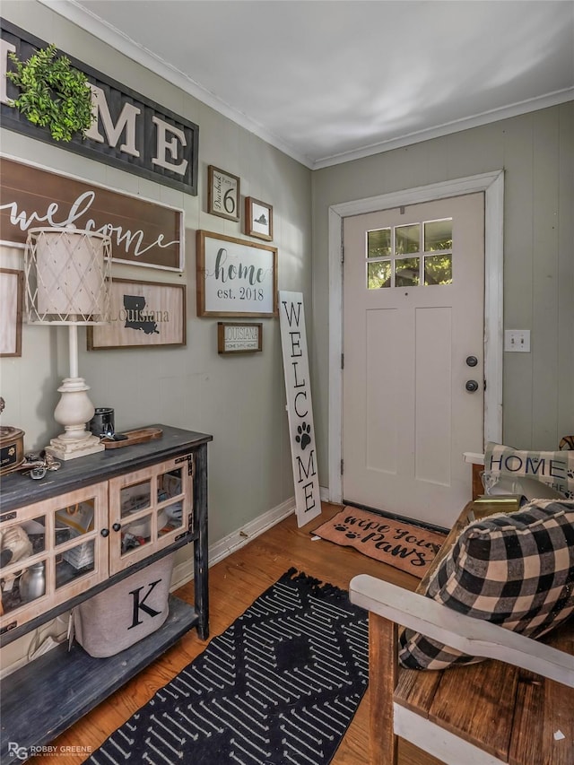 entrance foyer featuring ornamental molding and wood finished floors