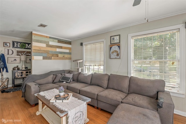 living area with a wealth of natural light, visible vents, and light wood-type flooring