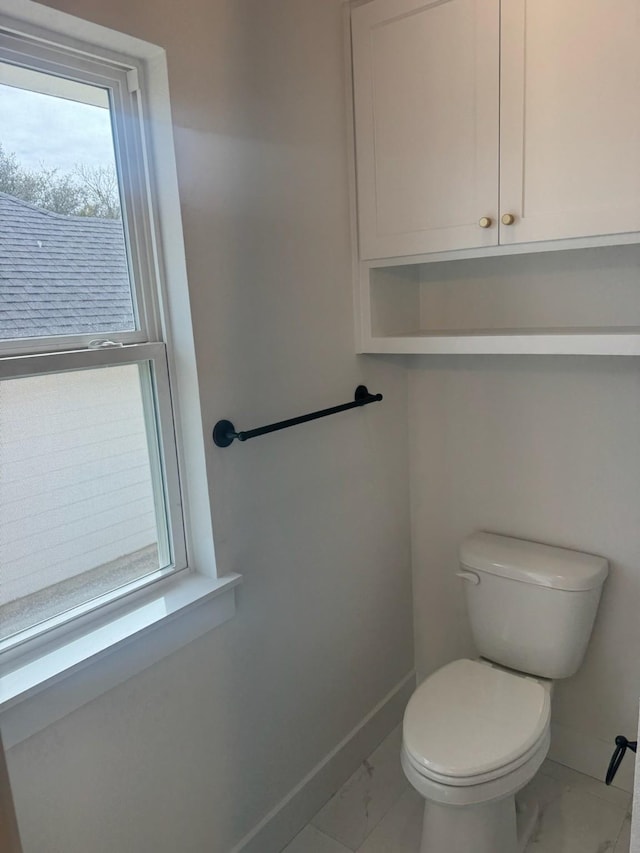 608 N Mill St, Weatherford, TX 76086 - bathroom featuring marble look tiles, baseboards, and toilet