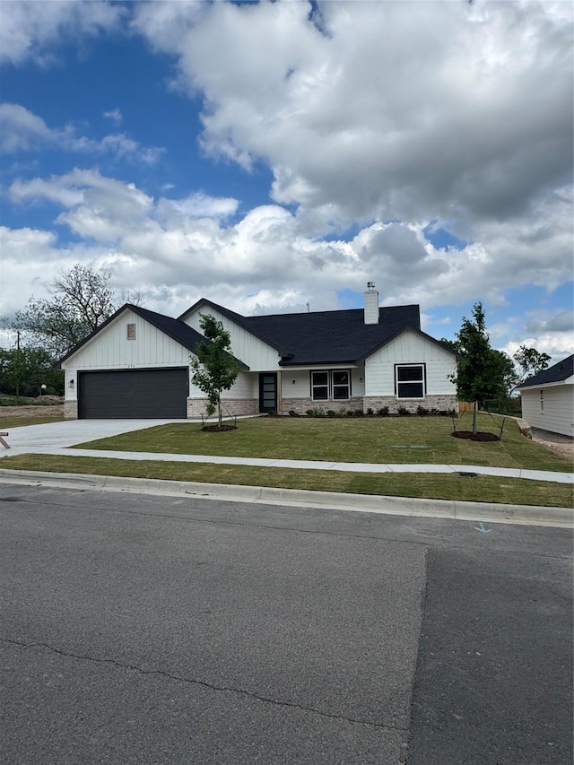 ranch-style house with driveway, a chimney, a front yard, and a garage