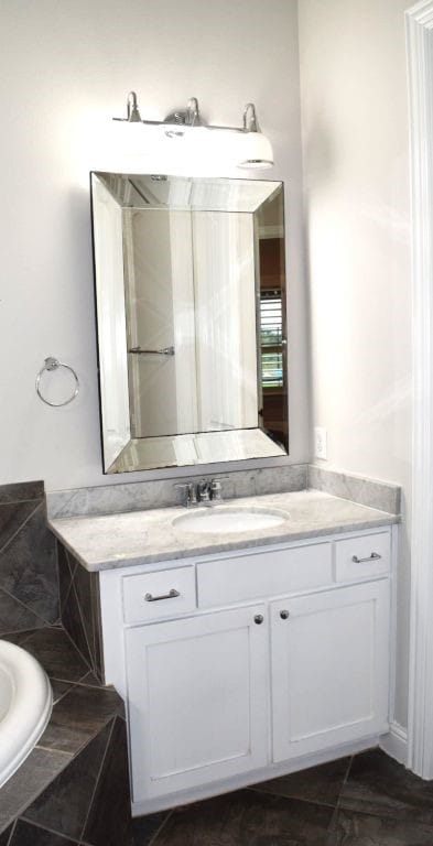 full bath featuring vanity and a tub to relax in