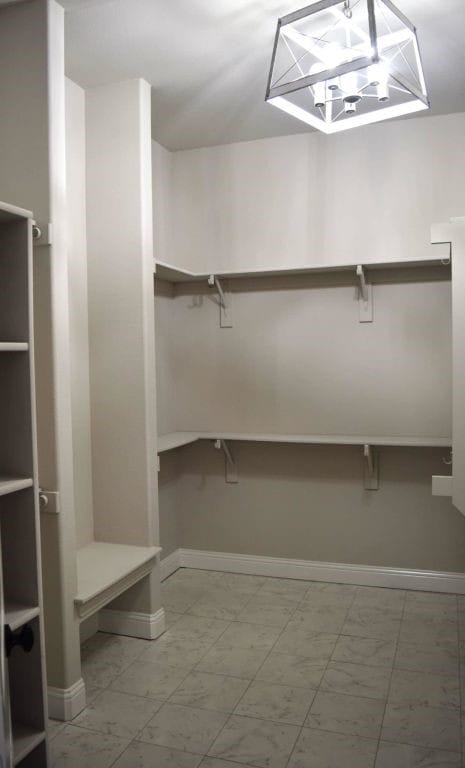 walk in closet featuring marble finish floor