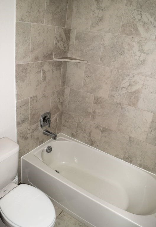 bathroom with toilet and  shower combination