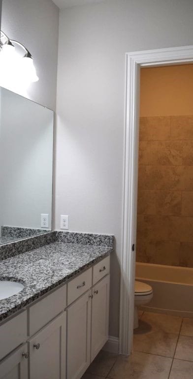 bathroom featuring toilet, tile patterned flooring, and vanity