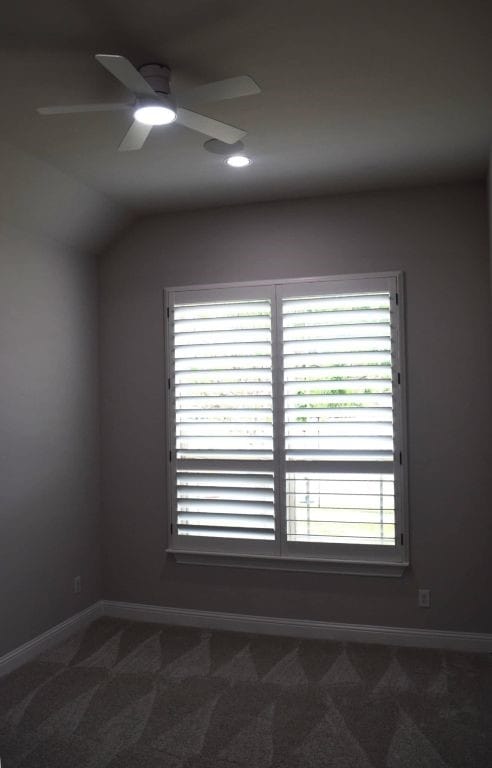 empty room featuring a healthy amount of sunlight, dark colored carpet, baseboards, and ceiling fan