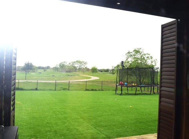 view of yard with fence and a trampoline