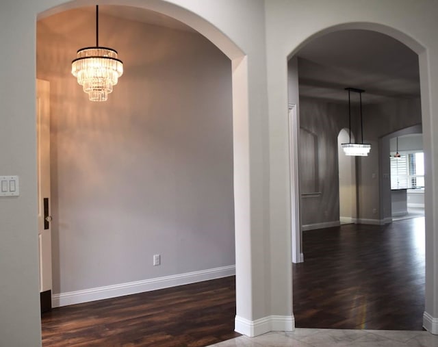 interior space with dark wood-type flooring, baseboards, and a chandelier