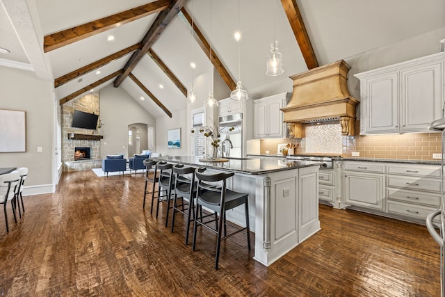 kitchen with open floor plan, high vaulted ceiling, custom exhaust hood, and beamed ceiling