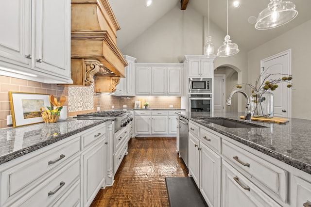 kitchen featuring white cabinets, beamed ceiling, a sink, and appliances with stainless steel finishes