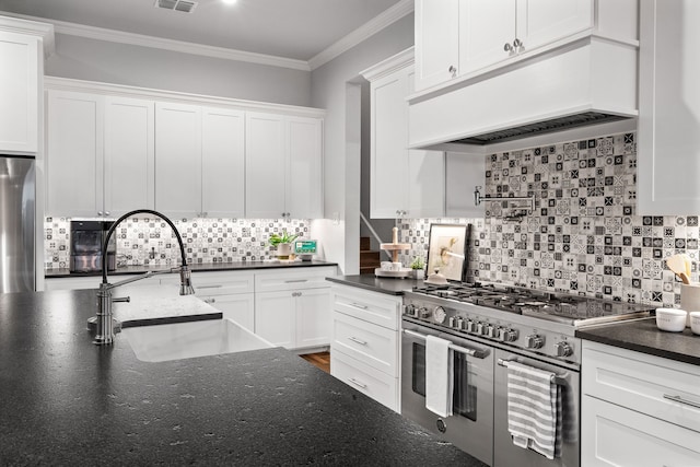 5685 Florance Rd, Northlake, TX 76247 - kitchen featuring appliances with stainless steel finishes, under cabinet range hood, a sink, white cabinetry, and tasteful backsplash