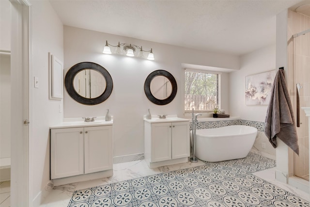 820 Craig Dr, Mesquite, TX 75181 - full bathroom featuring marble look tiles, a soaking tub, baseboards, and two vanities