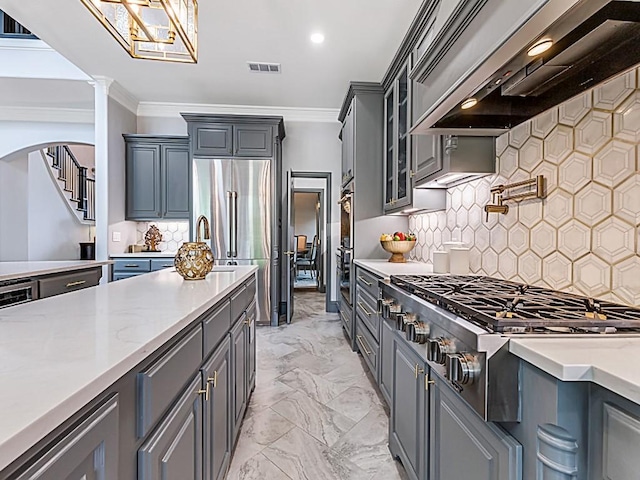 kitchen featuring stainless steel appliances, wall chimney exhaust hood, ornamental molding, gray cabinetry, and visible vents