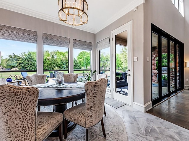 dining room featuring baseboards, crown molding, and a chandelier