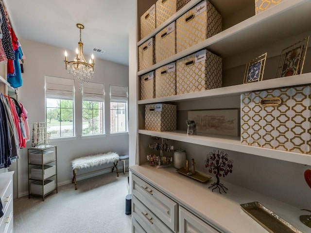 spacious closet featuring a chandelier, visible vents, and light colored carpet