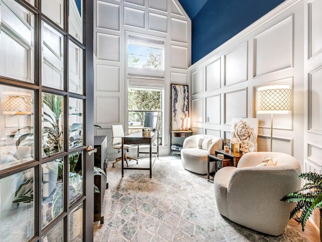 living area featuring a decorative wall and high vaulted ceiling