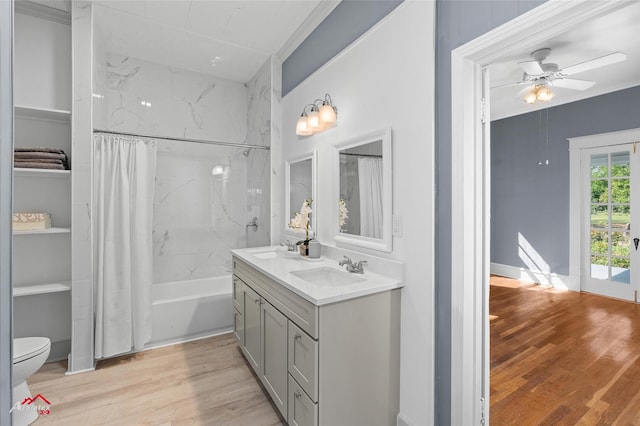 bathroom featuring a sink, toilet, a ceiling fan, and wood finished floors